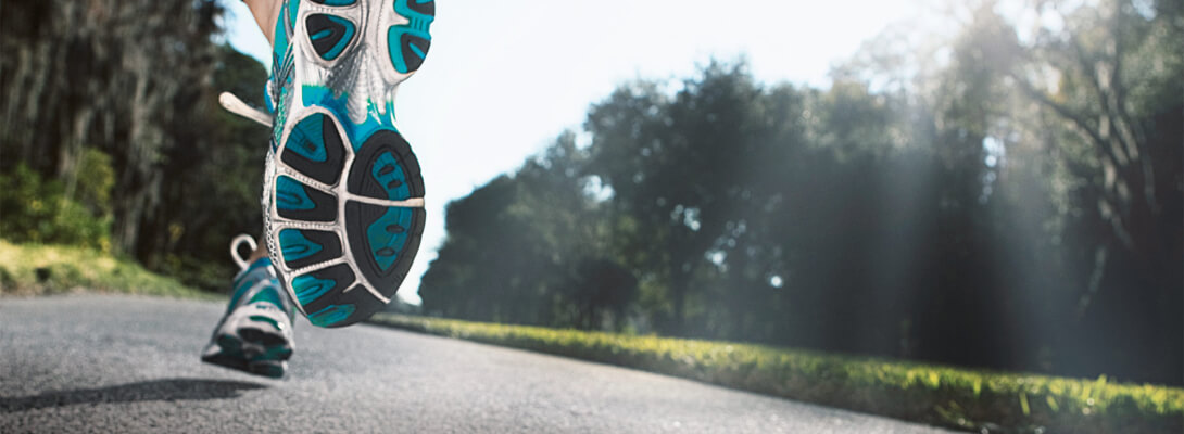 Laufen auf der Straße - Sportsocken Blick von einer Straße aus	 zeigt Laufschuhe von hinten