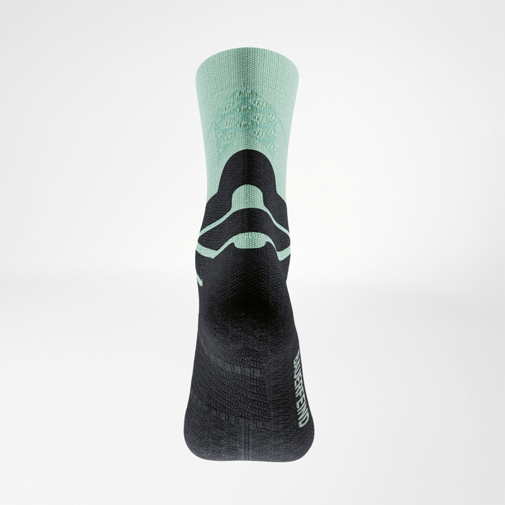 Rückansicht der grün‑schwarzen Run Performance Midcut Socke: grüne Schaftpartie mit 3D‑Dots, schwarzer Achillessehnen‑Komfortbereich und seitlich platziertes BAUERFEIND‑Logo.
