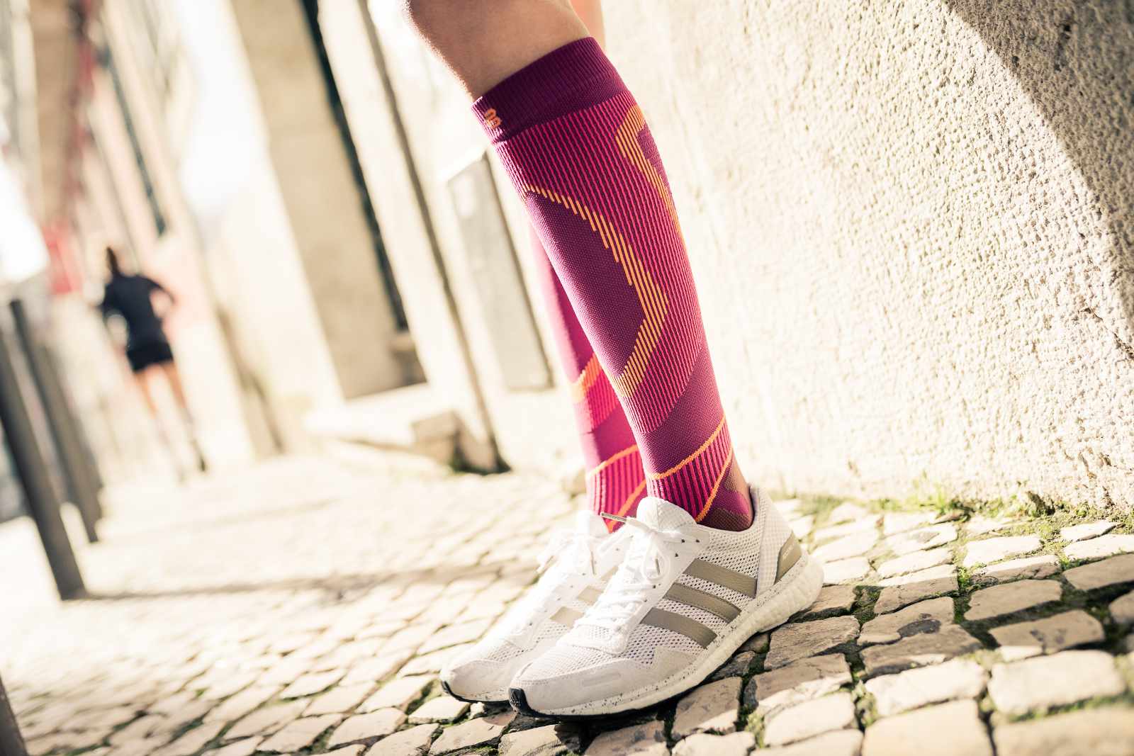 Nahaufnahme von bunten Laufsocken am Körper in einem urbanen Umfeld