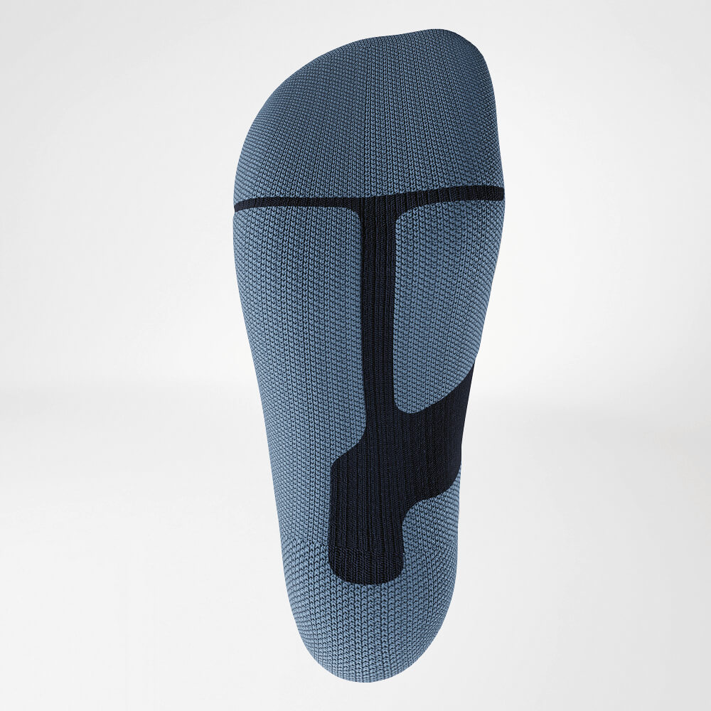 Nahaufnahme der Sohle einer blauen Ski-Kompressionssocke, die mit einem ergonomischen Strickmuster für Stabilität und Dämpfung ausgestattet ist. Entwickelt für maximalen Komfort bei intensiven sportlichen Aktivitäten.