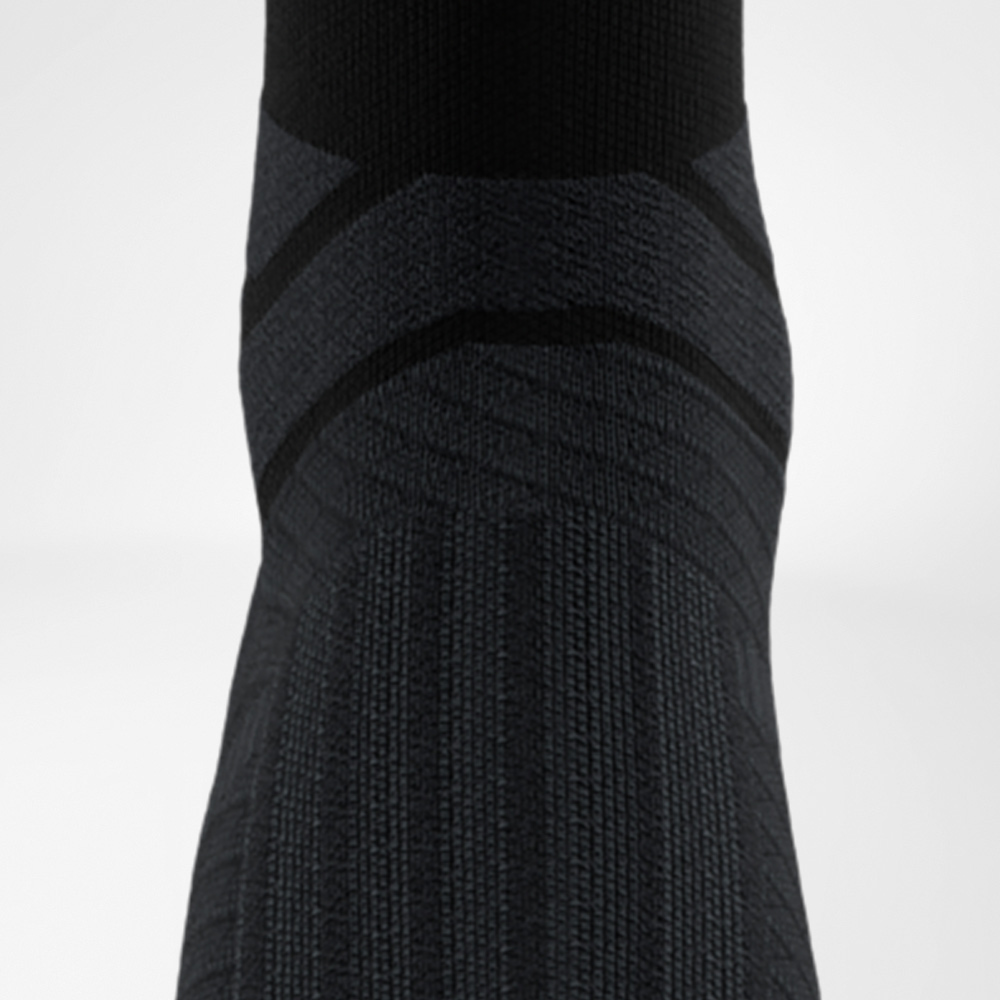 Kompression am Spann mit 3D-Dots für gezielten Support Nahaufnahme des Spannbereichs einer schwarzen Kompressionssocke mit 3D-Dots für gezielte Druckverteilung und Komfort beim Training.