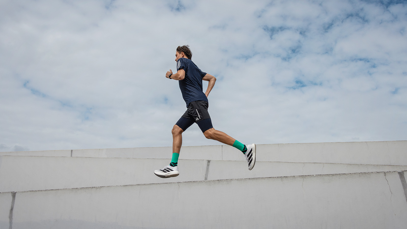 Auch mal Pause machen Läufer steht auf einer Erhöhung und blickt in die Ferne