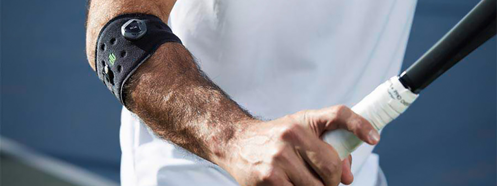 Tennisspieler mit Ellenbogenbandage hat Tennisschläger in der Hand