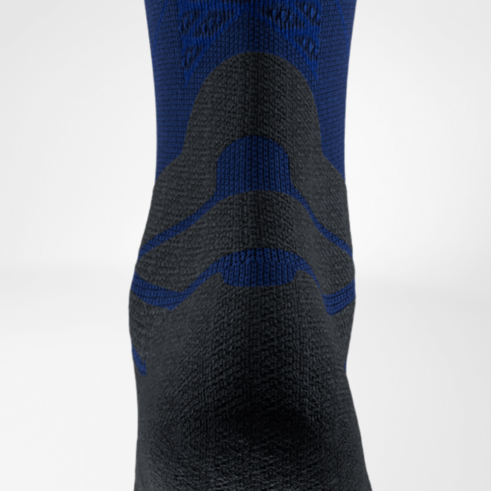 Detailaufnahme einer blau-schwarzen Laufsocke von Bauerfeind Sports, Rückansicht auf Höhe der Achillessehne. Das markante Polster schützt die Sehne vor Reibung im Schuh.