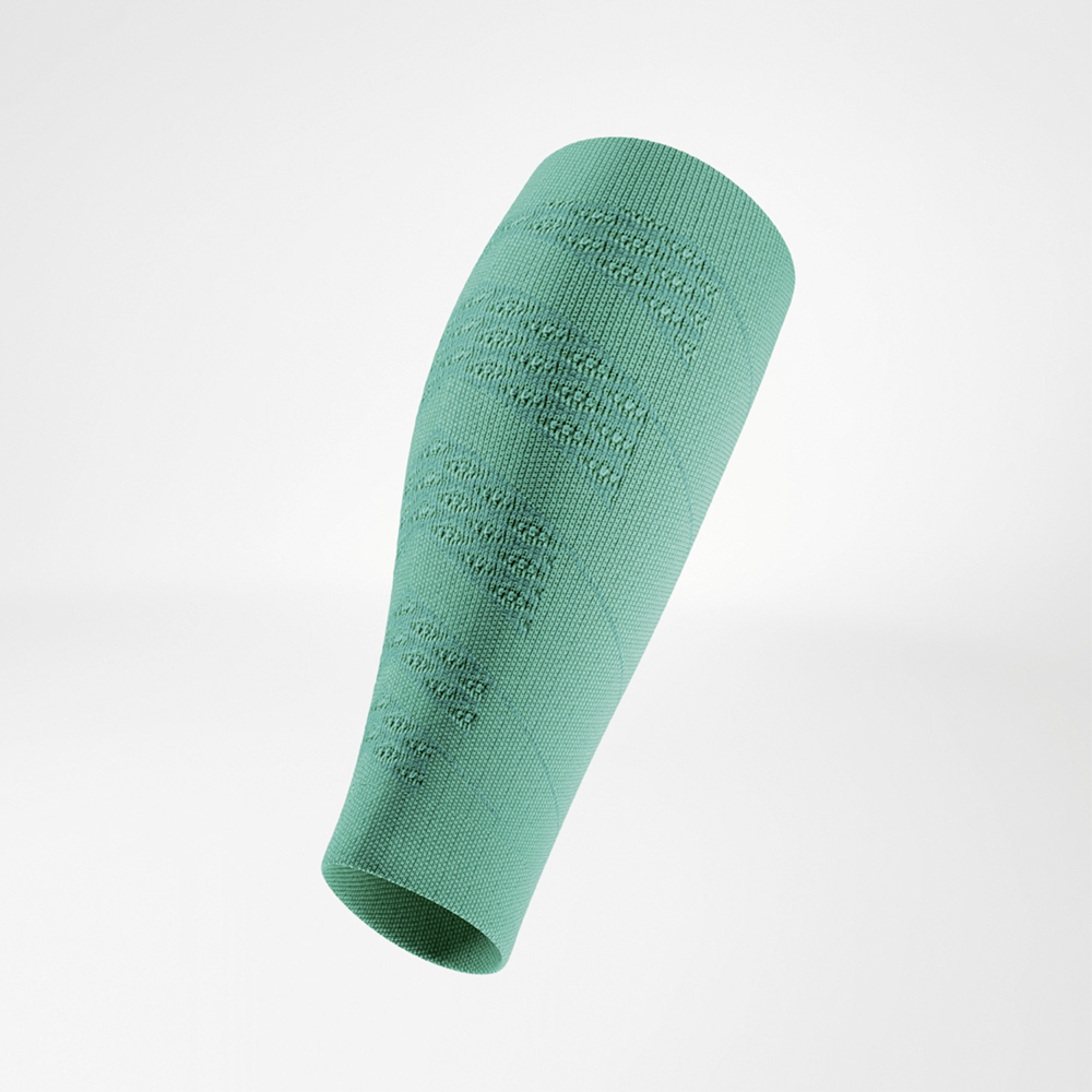 Grüner Kompressions-Sleeve in schräger Seitenansicht, frei schwebend. Das engmaschige Material zeigt eine auffällige Textur mit strukturierten Zonen, die für Stabilität und Belüftung sorgen.