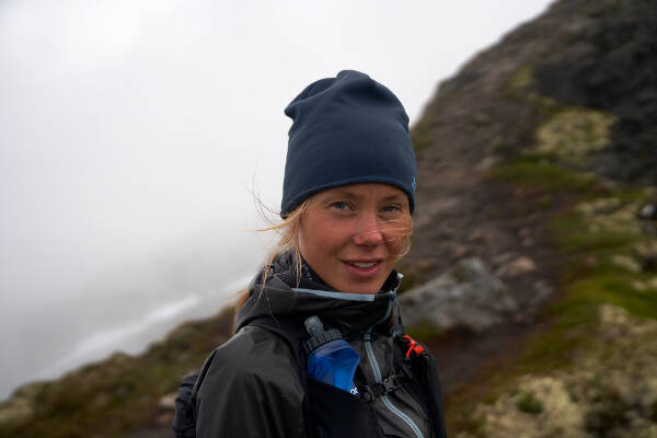 Portrait von Johanna Aström mit Mütze in rauher Gebirgslandschaft