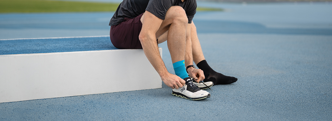 Läufer mit Compression Ankle Support beim Schuhe anziehen