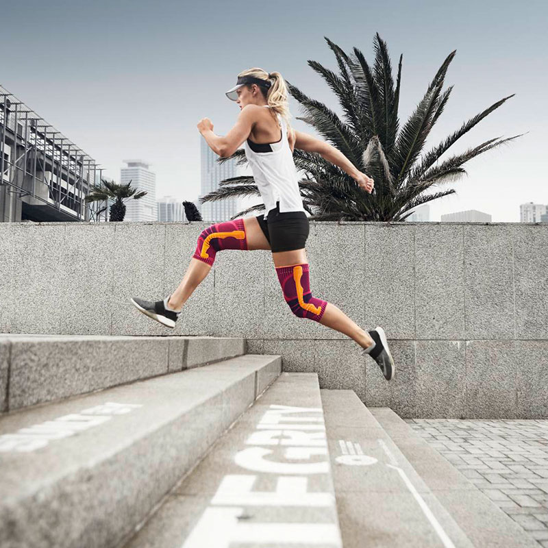 Läuferin springt mit Kniebandage über Treppen in der Stadt