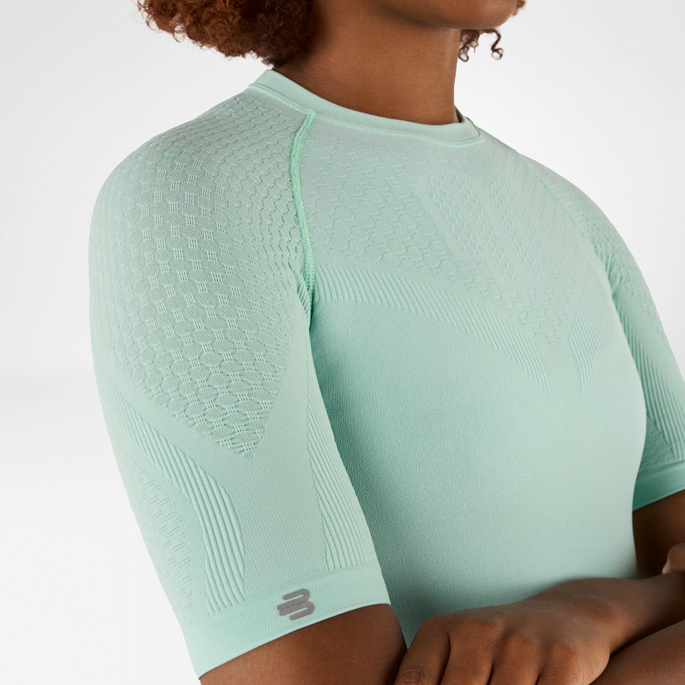 Seitliche Nahaufnahme eines mintgrünen Kompressionsshirts mit detailliertem strukturiertem Gewebe an der Schulter und dem Arm.