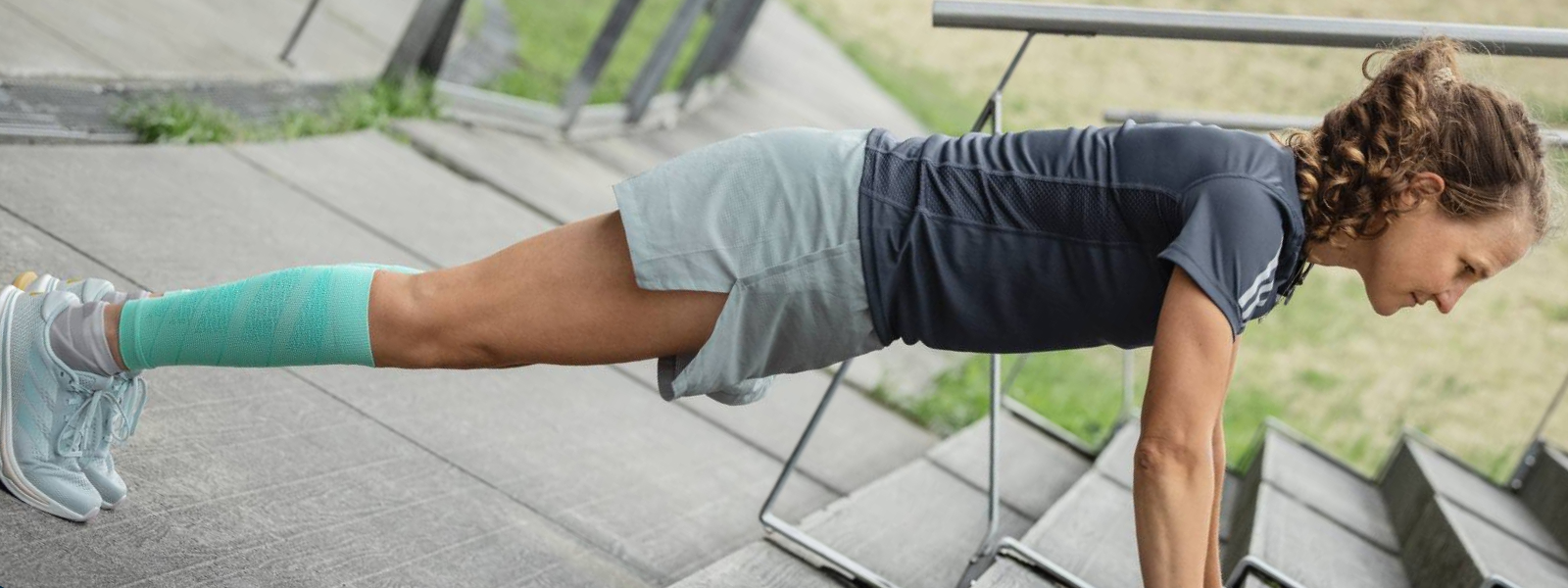 Frau macht Push-ups auf einem Betonboden	 Ansicht von schräg vorn