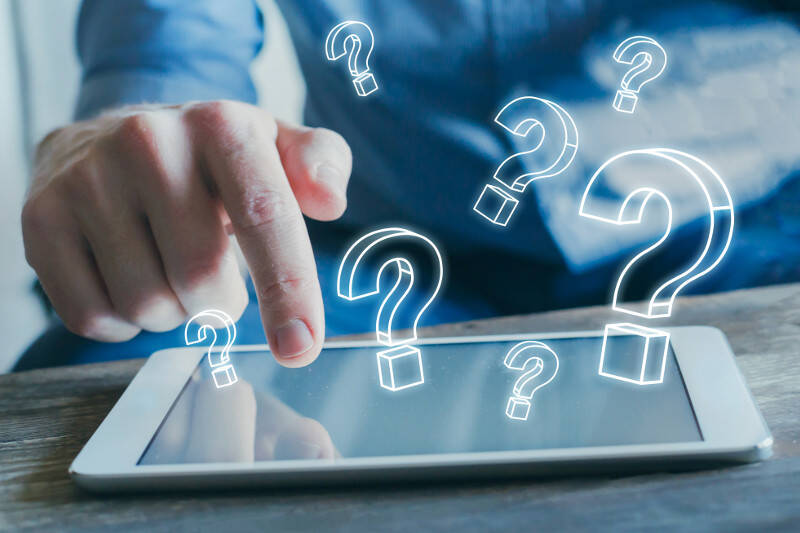 Bauerfeind Sports FAQs Mann tippt mit Zeigefinger auf Tabletdisplay	 darüber sind Fragezeichen ins Bild eingefügt