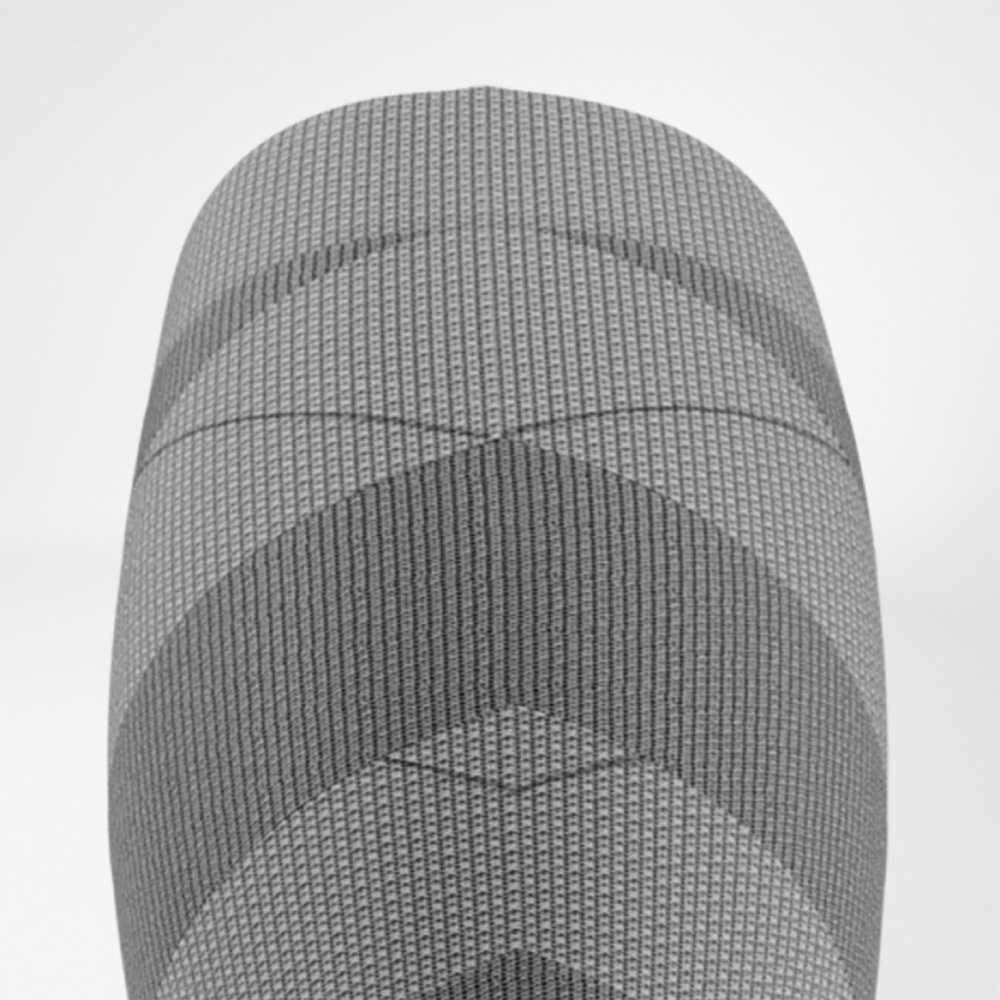Druckkontrolle mit System – fein abgestimmt bis unters Knie Detaillierte Draufsicht auf den oberen Bereich der Damen-Skikompressionssocke mit feinen Linien, Rippstrickmuster und abgestuften Kompressionszonen rund ums Knie.