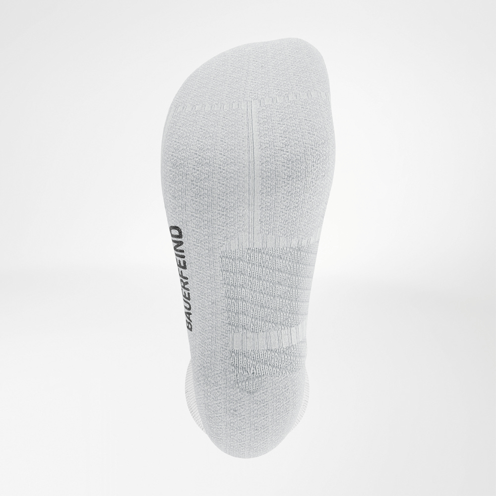 Nahaufnahme der Fußsohle der weißen Run Performance Socks von Bauerfeind mit sichtbarer Polsterung und eingestricktem BAUERFEIND-Logo.