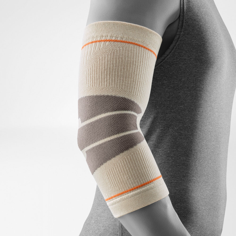 ie Outdoor Compression Elbow Support in der Farbe Sandstone wird am Arm getragen. Die Bandage liegt eng am Ellbogen an und zeigt ihre anatomisch geformten Kompressionszonen