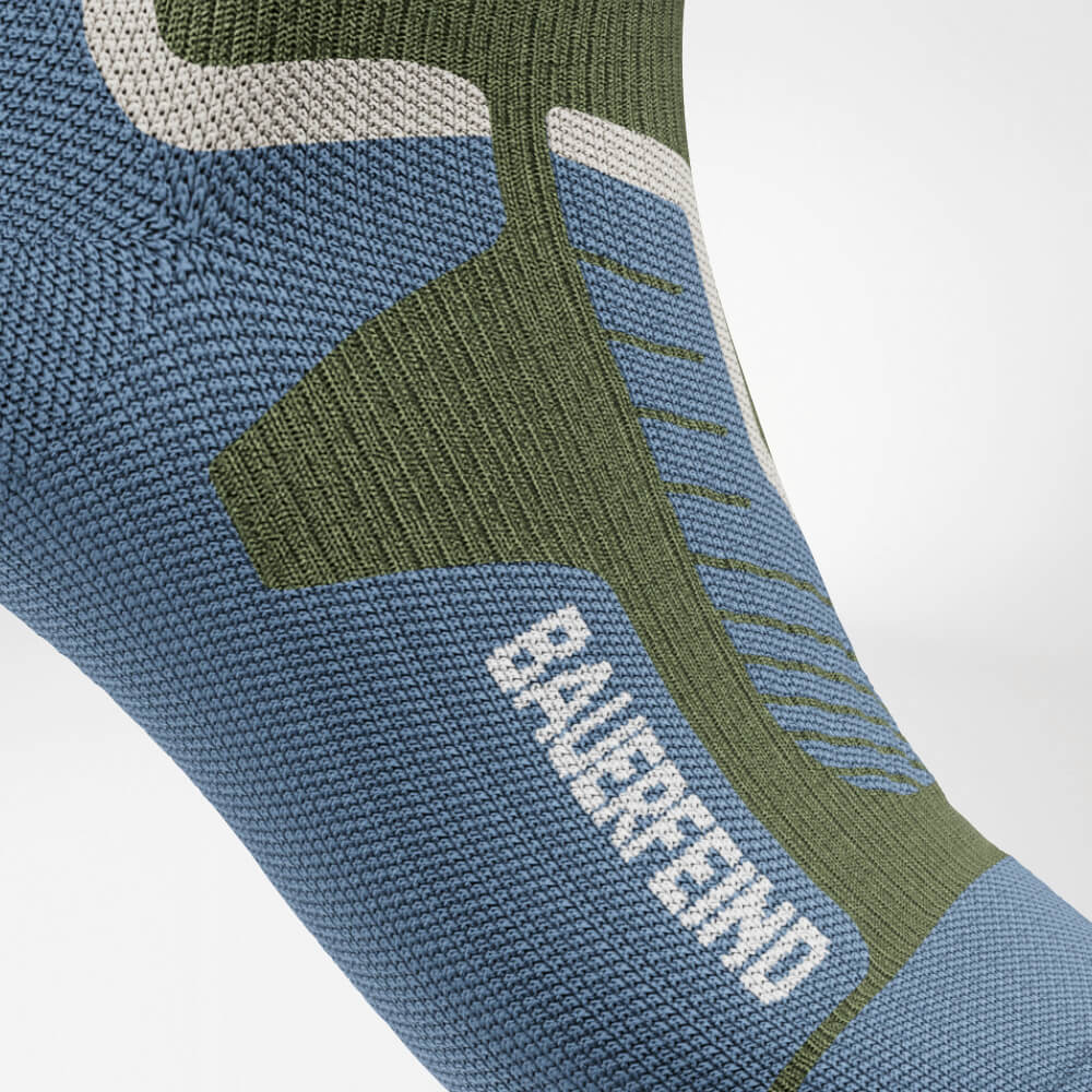 Nahaufnahme des Spanns einer grünen Ski-Kompressionssocke mit verstärktem, ergonomischem Strickdesign. Bietet optimalen Halt und Druckverteilung für maximalen Komfort während intensiver sportlicher Aktivitäten.