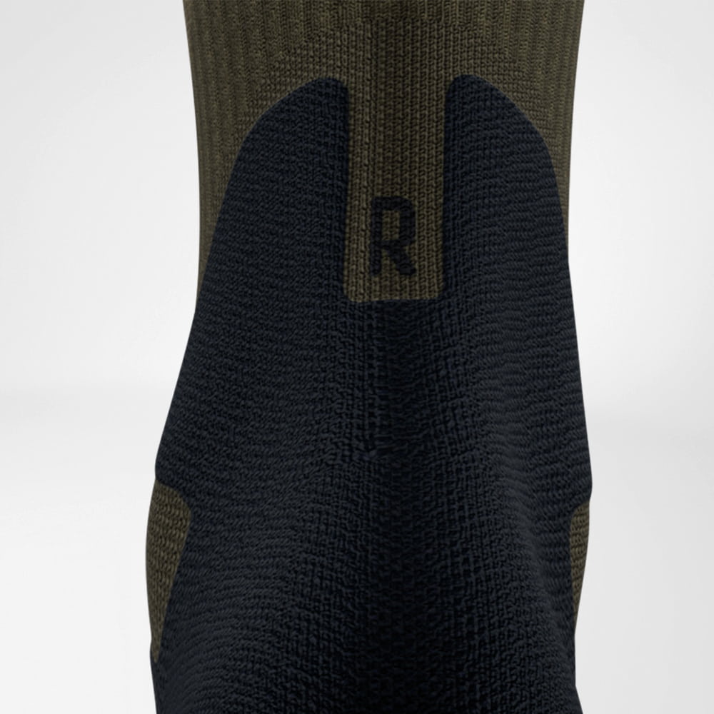 Komfort, der dich schützt: Die Details machen den Unterschied! Detailaufnahme der Merino Outdoor Socks in der Rückansicht. Die nahtlose Verarbeitung und die gezielte Polsterung der Achillessehne bieten Komfort und Schutz für lange Outdoor-Einsätze.