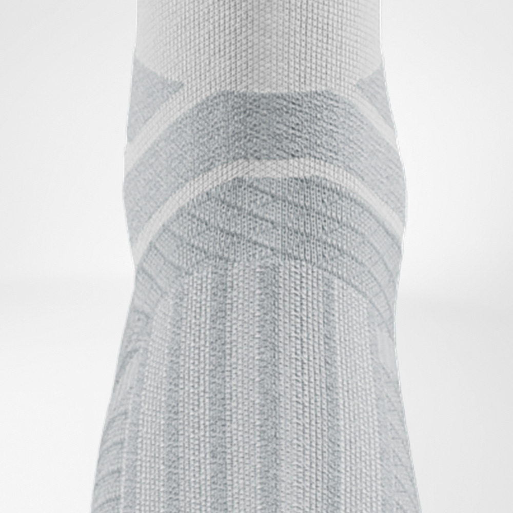Detailansicht des Sprunggelenks der weißen Run Performance Socks mit anatomischer Polsterung und Stützstrukturen.