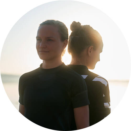 Langstreckenläuferinnen Anna und Lisa stehen Rücken an Rücken für ein Portrait	 runder Bildausschnitt