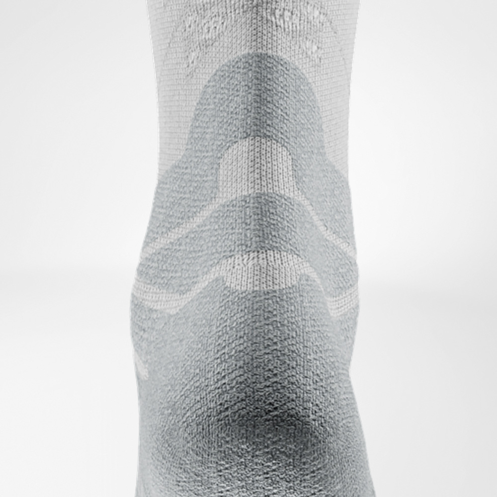 Detailaufnahme des Achilles-Komfortpolsters der weißen Run Performance Socks zur Entlastung der Achillessehne.