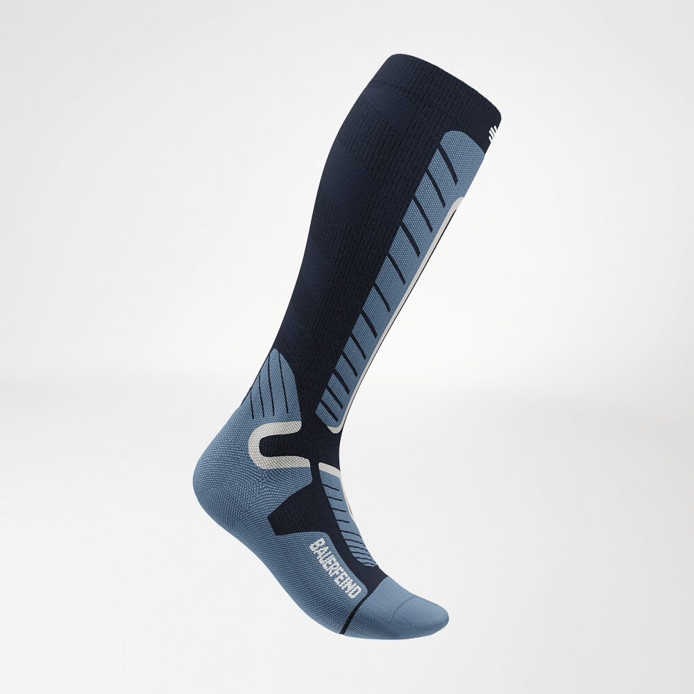 Seitenansicht einer blauen Ski-Kompressionssocke, die bis unter das Knie reicht. Mit verstärktem Strickmuster für maximale Unterstützung und Komfort während des Skifahrens.