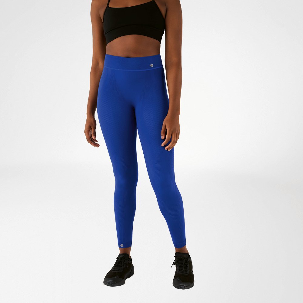 Eine Frau in schwarzem Sport-BH und marineblauer, knöchellangen Sporthose in High Waist
