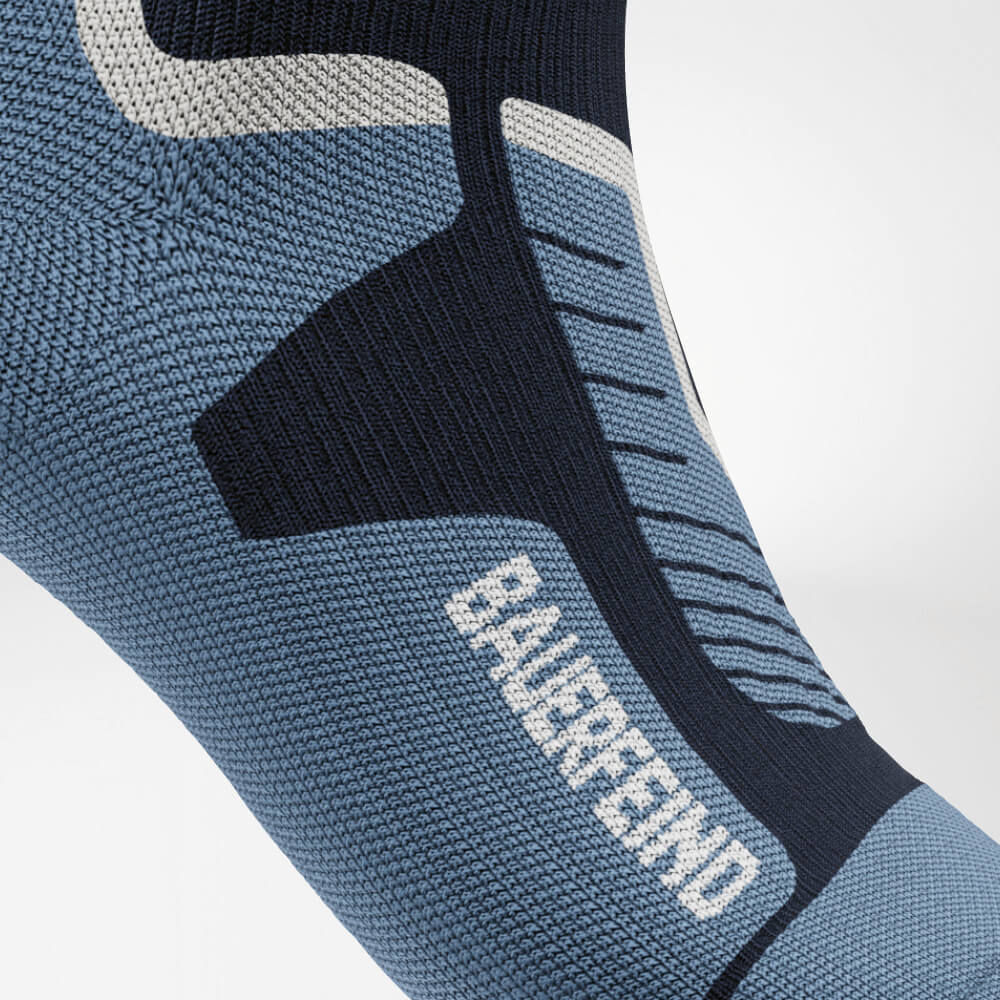 Nahaufnahme des Spanns einer blauen Ski-Kompressionssocke mit verstärktem Strickmuster, das für optimale Unterstützung und Druckverteilung sorgt. Perfekt für lange Tage auf der Piste.