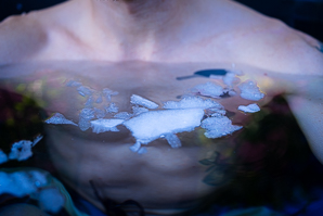 Mann beim Eisbaden im Wasser mit Eisstücken.