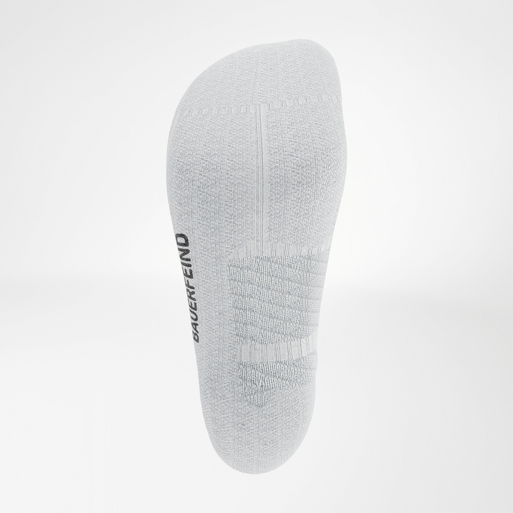 Ansicht der Unterseite der weißen Run Performance Low Cut Socks von Bauerfeind mit sichtbaren Komfort- und Kompressionszonen im Mittelfußbereich.