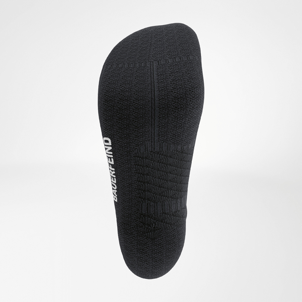 Detaillierte Unteransicht der schwarzen Run Performance Low Cut Socks von Bauerfeind mit strukturierter Fußsohle zur Unterstützung der Fußgewölbe.