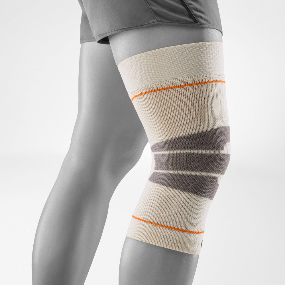 Sandfarbene Kniebandage für Outdoor-Sportarten, seitlich am Bein präsentiert. Das atmungsaktive Material sorgt für angenehmen Tragekomfort und Stabilität, ideal für Wanderungen und Läufe im Freien.