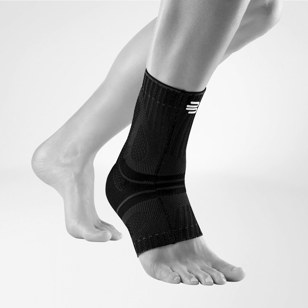 Seitliche Komplettansicht der schwarzen Achillessehnenbandage am stilisierten grauen Fuß