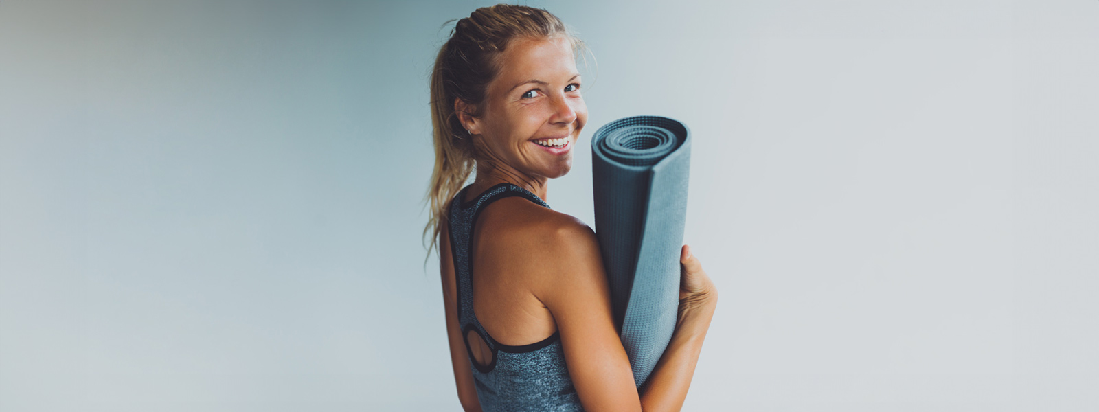 Yoga ist gut für Körper und Geist Lächelnde Frau mit Yogamatte