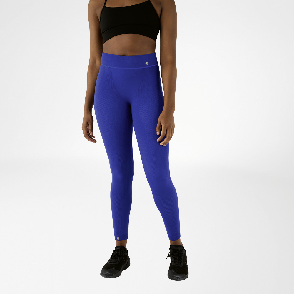 Eine Frau in schwarzem Sport-BH und marineblauer, knöchellangen Sporthose in High Waist