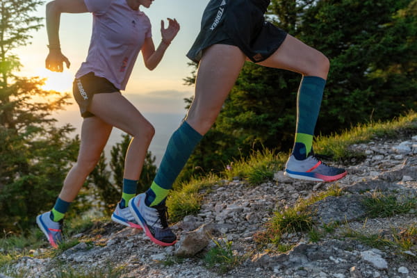 Bauerfeind Trailrun Socks in Aktion Hahner Zwillinge laufen einen Trail hoch und tragen dabei Trail Run Socken