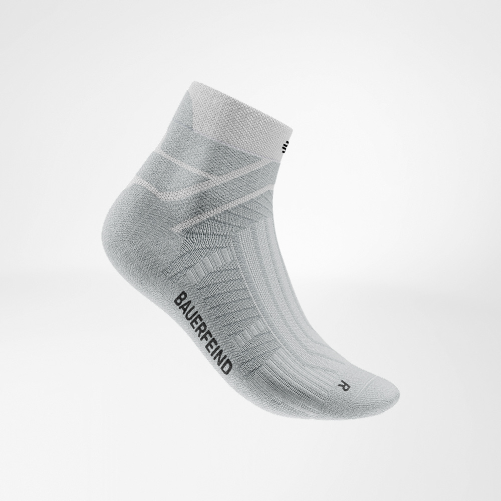 Weiße Run Performance Low Cut Socke von Bauerfeind in seitlicher Ansicht, mit sichtbarem Strickmuster, atmungsaktiven Zonen und Bauerfeind-Schriftzug an der Außenseite.