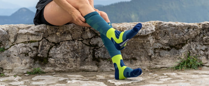 Frau zieht Compression Socks an und ist beim letzten Schritt diese hochzuziehen