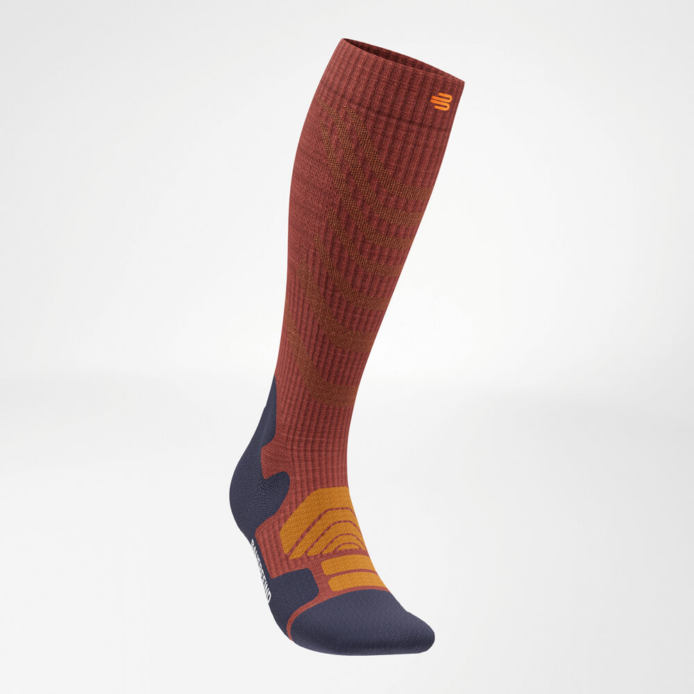 Die Bauerfeind Sports Merino Outdoor Socks in Granat in schräger Frontalansicht von links, mit Fokus auf die ergonomische Passform und das ansprechende Farbmuster.