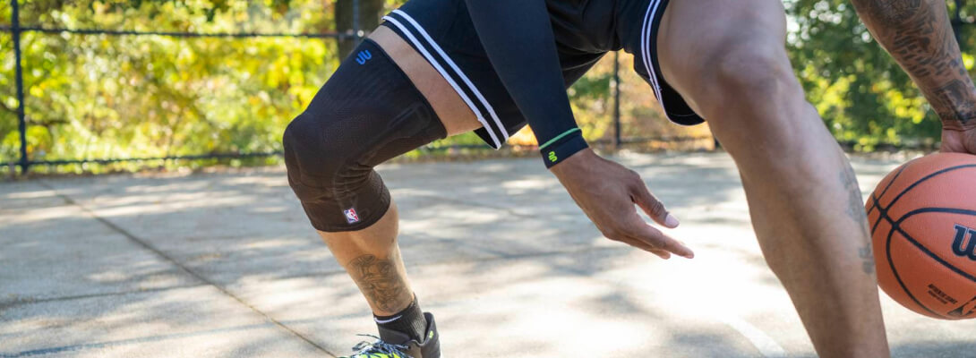 Kniebandage NBA beim Basketball Basketballer beim Dribbeln trägt eine Sports Knee Support NBA