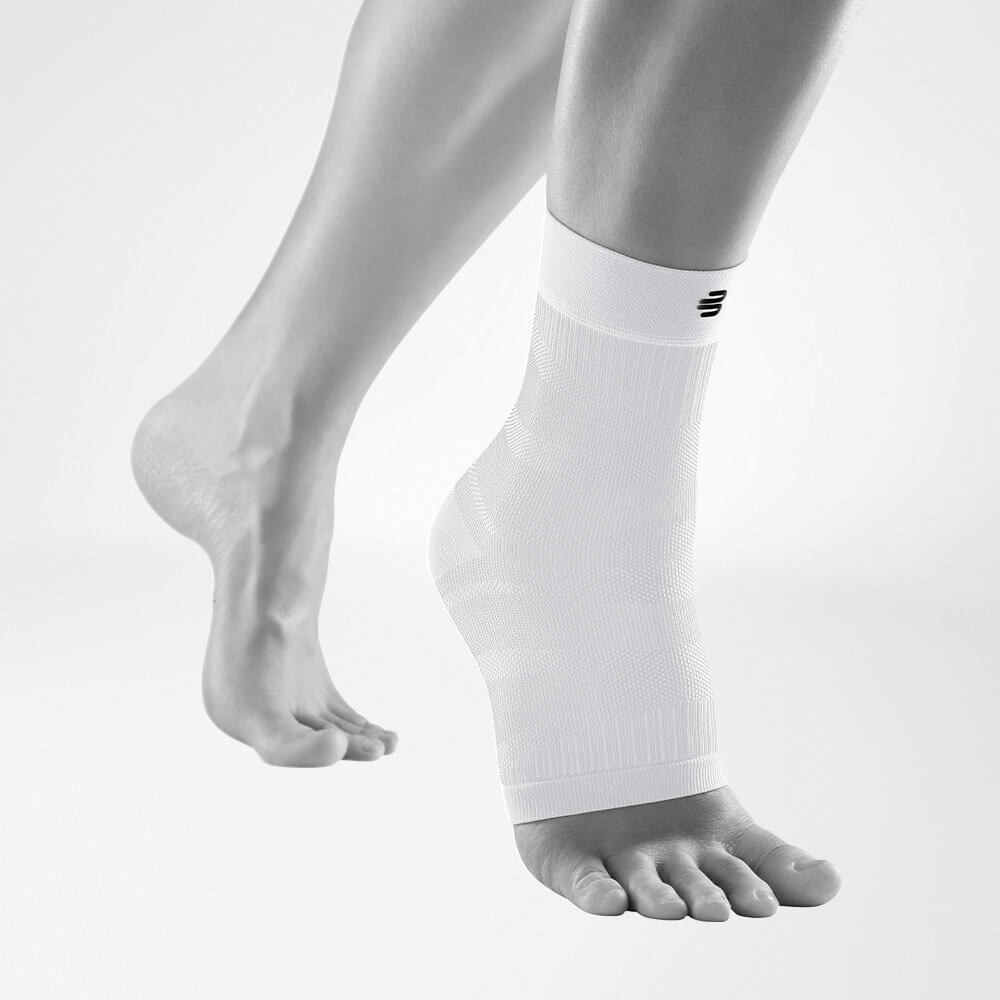 Komplettansicht der weißen Compression Ankle Support an einem stilisierten grauen Bein