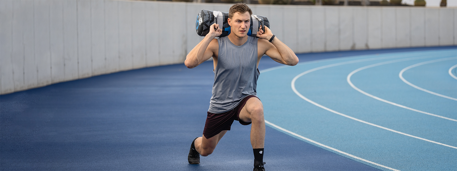 Squats mit Sprunggelenksbandage Thomas Röhler macht auf einer Laufbahn Squats mit einem Gewicht auf dem Rücken und einer Sprunggelenkbandage am Fuß