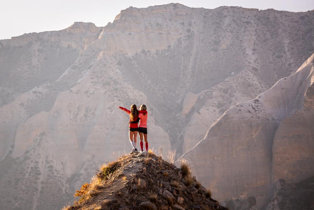 Zwei Frauen jubeln auf einem Berggipfel