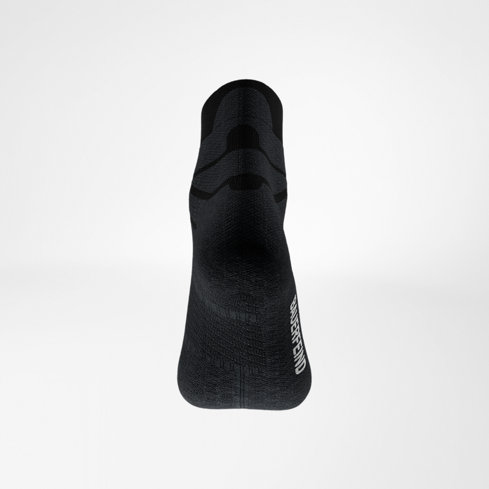Rückansicht der schwarzen Run Performance Low Cut Socke von Bauerfeind, Ferse im Fokus, feine Strickstruktur und Logo an der Seite sichtbar.