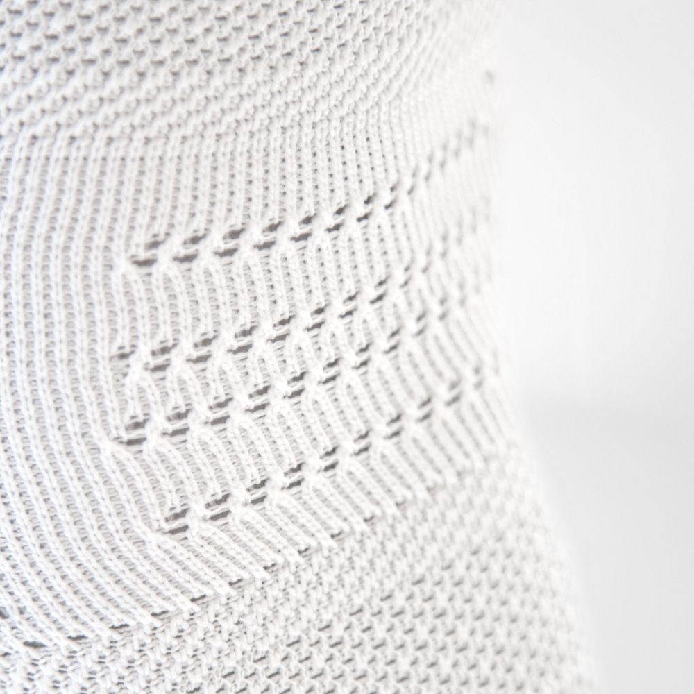 Detailansicht des atmungsaktiven Gestricks in der Kniekkehle der weißen Kniebandage für den Sport NBA Version