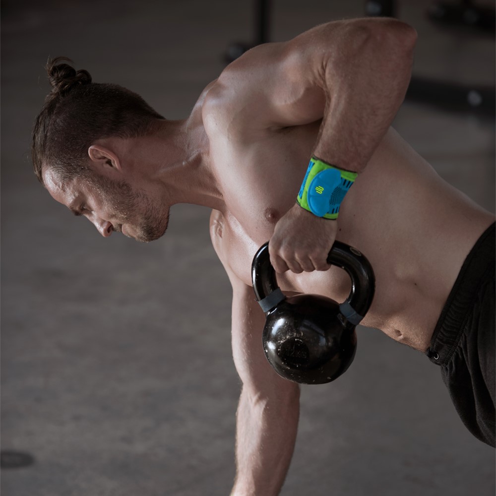 Mann beim Kettlebell Training mit Handgelenkbandage für den Sport