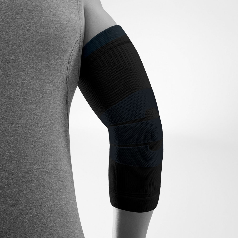 Seitliche Ansicht der schwarzen Outdoor Compression Elbow Support am Arm einer Person. Die Kompressionsbandage umschließt den Ellenbogen und den Unterarm und zeigt unterschiedliche gestrickte Zonen